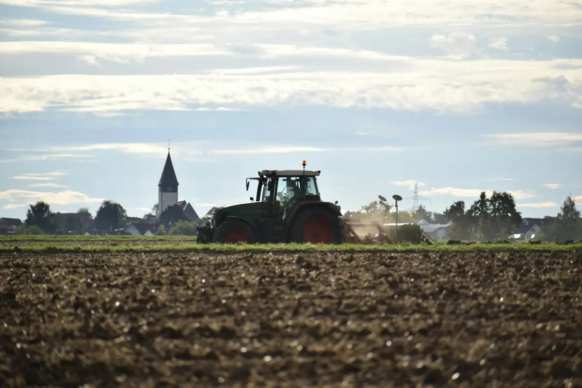red tractor on brown field during daytime